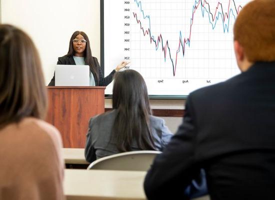 Student making a presentation in front of a graph